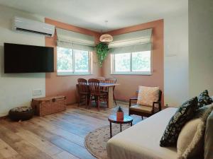 a living room with a couch and a dining room at בדרך לנחל הבניאס in Sde Nehemia