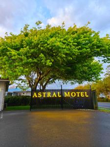 a sign that reads ashfield motel in front of a tree at Astral Motel in Whanganui