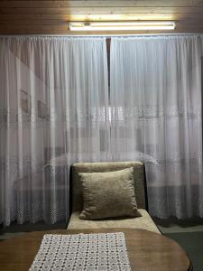 a bedroom with a bed and a window with curtains at Kuća za odmor Sremac in Apatin