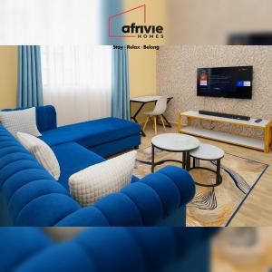 a living room with a blue couch and tables at Afrivie Homes Apartments in Kisii in Kisii