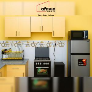 a kitchen with a stove and a microwave at Afrivie Homes Apartments in Kisii in Kisii