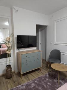 乌日策Apartman Karamelica的一间设有梳妆台、电视和椅子的房间