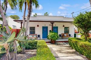 una casa con una puerta azul y palmeras en Tropical Vibes, en Key West