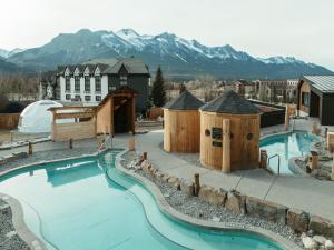 キャンモアにあるEverwild Canmore - Nordic Spa & Hotelの建物と山々を背景にした大きなプール