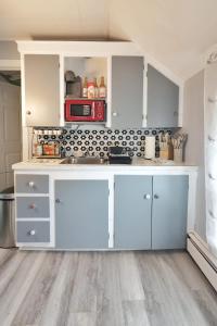 a kitchen with white cabinets and a red microwave at Chic & Sunny 1BR Hideaway- Apt 1 in Bridgewater