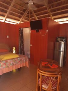a bedroom with a bed and a table and a tv at Monita Villa Rangiroa in Tiputa