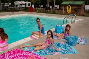 een groep meisjes die rond een zwembad zitten bij Jellystone Park PA Wilds in Mansfield