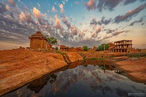 a reflection of a building in a body of water at Dream Hampi Villa & Home Stay in Hampi