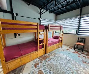 a room with two bunk beds and a chair at Canova Hostel & Pizza in Puerto Vallarta