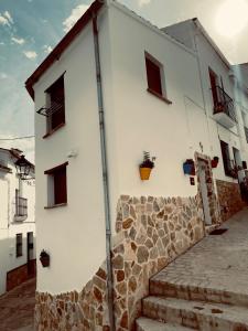 - un bâtiment blanc avec des escaliers devant dans l'établissement Pequeña África en El Gastor, à El Gastor