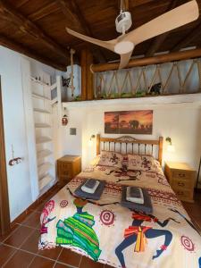 une chambre avec un lit et un ventilateur de plafond dans l'établissement Pequeña África en El Gastor, à El Gastor