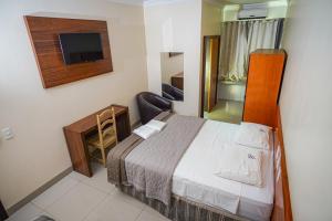a hotel room with a bed and a television at Garcia Palace Hotel in Sinop