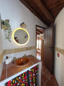 une salle de bain avec un lavabo et un miroir au mur dans l'établissement Pequeña África en El Gastor, à El Gastor