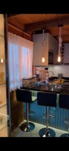 a kitchen with a counter and two bar stools at Minha house in Navegantes