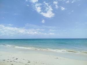 a beach with the ocean and a blue sky and clouds at Hotel El Almendro in Pedernales