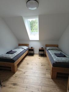 two beds in a room with a window at Apartmány na Žlábku in Horní Planá