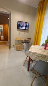 a living room with a table and a tv on the wall at Weranda in Bytom