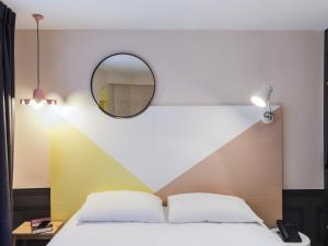 a bedroom with a bed with a mirror on the wall at ibis Styles Paris Gare de l'Est TGV in Paris
