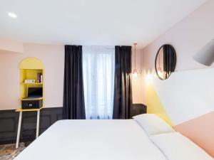 a hotel room with a white bed and a window at ibis Styles Paris Gare de l'Est TGV in Paris +37 photos
