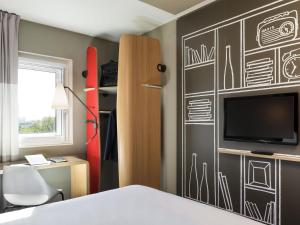 a bedroom with a bed and a wall with drawings on it at ibis Paris Saint-Denis Stade Sud in Saint-Denis +39 photos