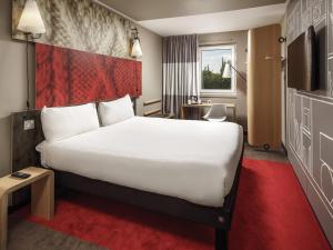 a hotel room with a large bed and a tv at ibis Coventry Centre in Coventry
