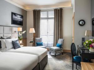 una habitación de hotel con una cama y un escritorio en Sofitel Paris Baltimore Tour Eiffel, en París 140 fotos más