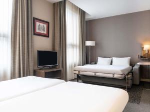 a hotel room with two beds and a television at Aparthotel Adagio La Défense Esplanade in Puteaux +51 photos