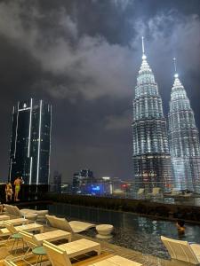 a view of the petronas twin towers at night at Star Infinity Pool At Klcc in Kuala Lumpur