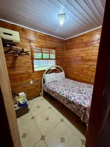 ein kleines Zimmer mit einem Bett in einer Holzhütte in der Unterkunft Sítio reservado com piscina in Viamão