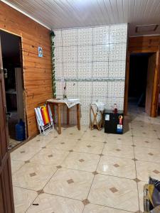 ein Zimmer mit einem Tisch und einem Fliesenboden in der Unterkunft Sítio reservado com piscina in Viamão