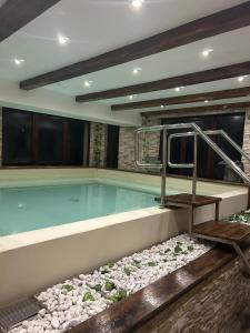 a large swimming pool with rocks around it at Hotel B dracula in Bran
