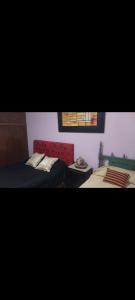 ein Schlafzimmer mit zwei Betten und einer roten Couch in der Unterkunft Gustavo 2 in Villa Mercedes