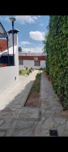 einen Steinweg neben einem Gebäude mit Pflanzen in der Unterkunft Gustavo 2 in Villa Mercedes