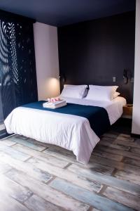 a bedroom with a large bed with white sheets at The Coffee Club Apartahotel in Manizales