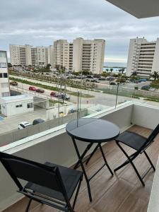 Depto a pasos de la playa, vistas al mar في لا سيرينا: طاولة وكراسي على شرفة مطلة على المدينة