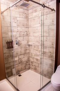 a shower with a glass door in a bathroom at The Coffee Club Apartahotel in Manizales