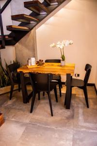 a wooden table and chairs with a vase of flowers on it at The Coffee Club Apartahotel in Manizales +54 photos