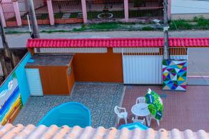 a patio with a table and chairs and an umbrella at Pousada mirante do Sol in Piúma