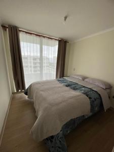 Depto a pasos de la playa, vistas al mar في لا سيرينا: سرير في غرفة نوم ذات نافذة كبيرة