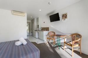 a room with a bed and a table and chairs at Capricorn Motel & Conference Centre in Rockhampton