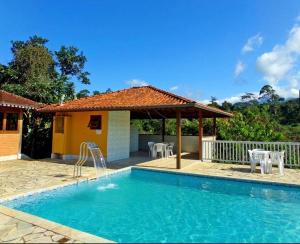 ein Swimmingpool vor einem Haus in der Unterkunft Chalé Canário da Terra 2 in Visconde De Maua