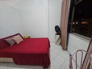 a bedroom with a red bed and a window at A uma quadra da praia de Copacabana in Rio de Janeiro