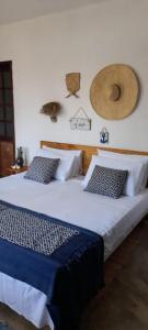 a bedroom with a large bed with blue sheets and pillows at Pousada Ventoria in Canguaretama