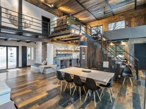 a living room with a table and a staircase at Vue panoramique Spa Moderne in Sainte-Lucie-de-Doncaster