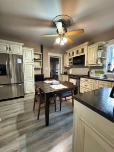 eine Küche mit einem Tisch und einem Deckenventilator in der Unterkunft THE RED HOUSE in Niagara Falls + 72 Fotos