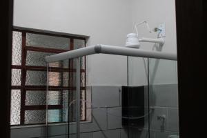 ein Duschkopf in einem Badezimmer mit Fenster in der Unterkunft Vila Azular Ubatuba 50m da Praia, Casas Completas & Estacionamento in Ubatuba + 36 Fotos
