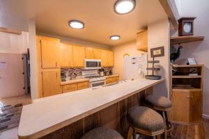 a kitchen with wooden cabinets and a counter with stools at Creekside Chalet Stay for 6 in Kings Beach
