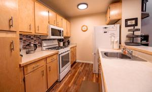 a kitchen with a white refrigerator and a sink at Creekside Chalet Stay for 6 in Kings Beach