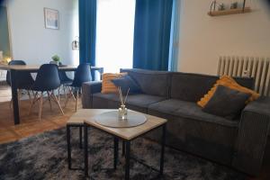 a living room with a couch and a table at Le Beauregard, 2 chambres, Hyper Centre de Beauvais in Beauvais
