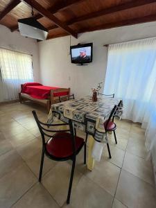 ein Wohnzimmer mit Tisch und Stühlen und einem Fernseher in der Unterkunft Aneley Cabañas Bosque Peralta Ramos in Mar del Plata